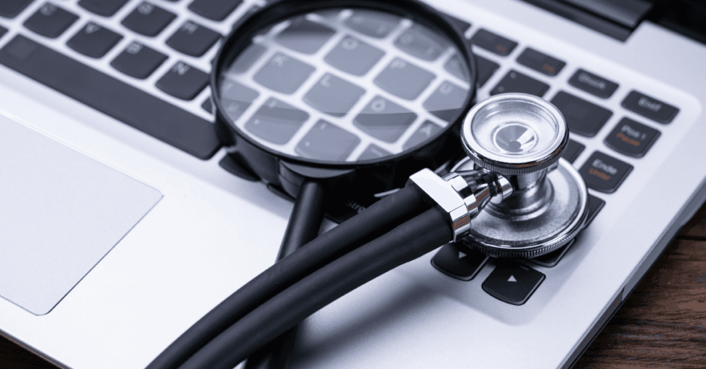 Health Trackers online showing a magnifying glass next to a stethoscope on a computer.