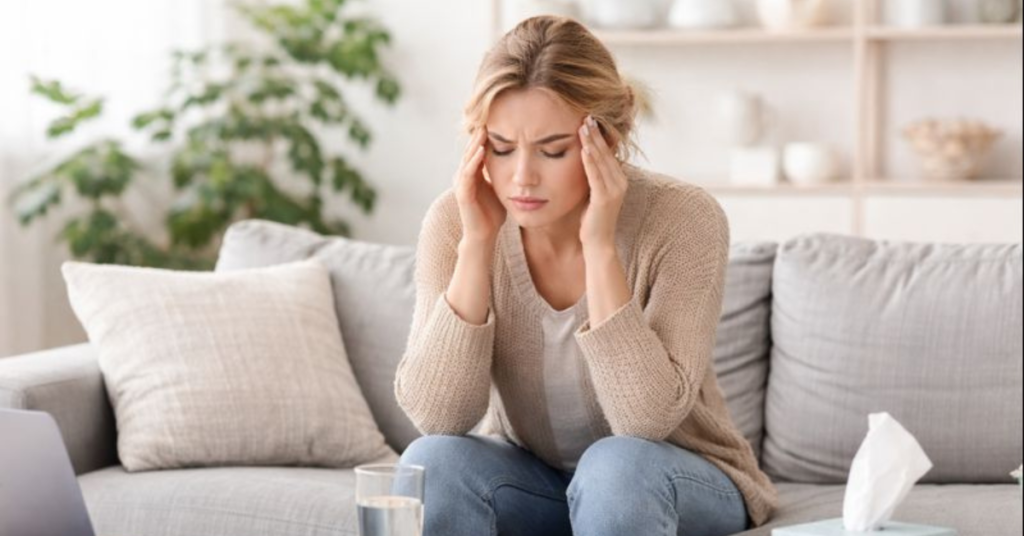 Woman showing signs of stress at home, illustrating high cortisol levels and tension